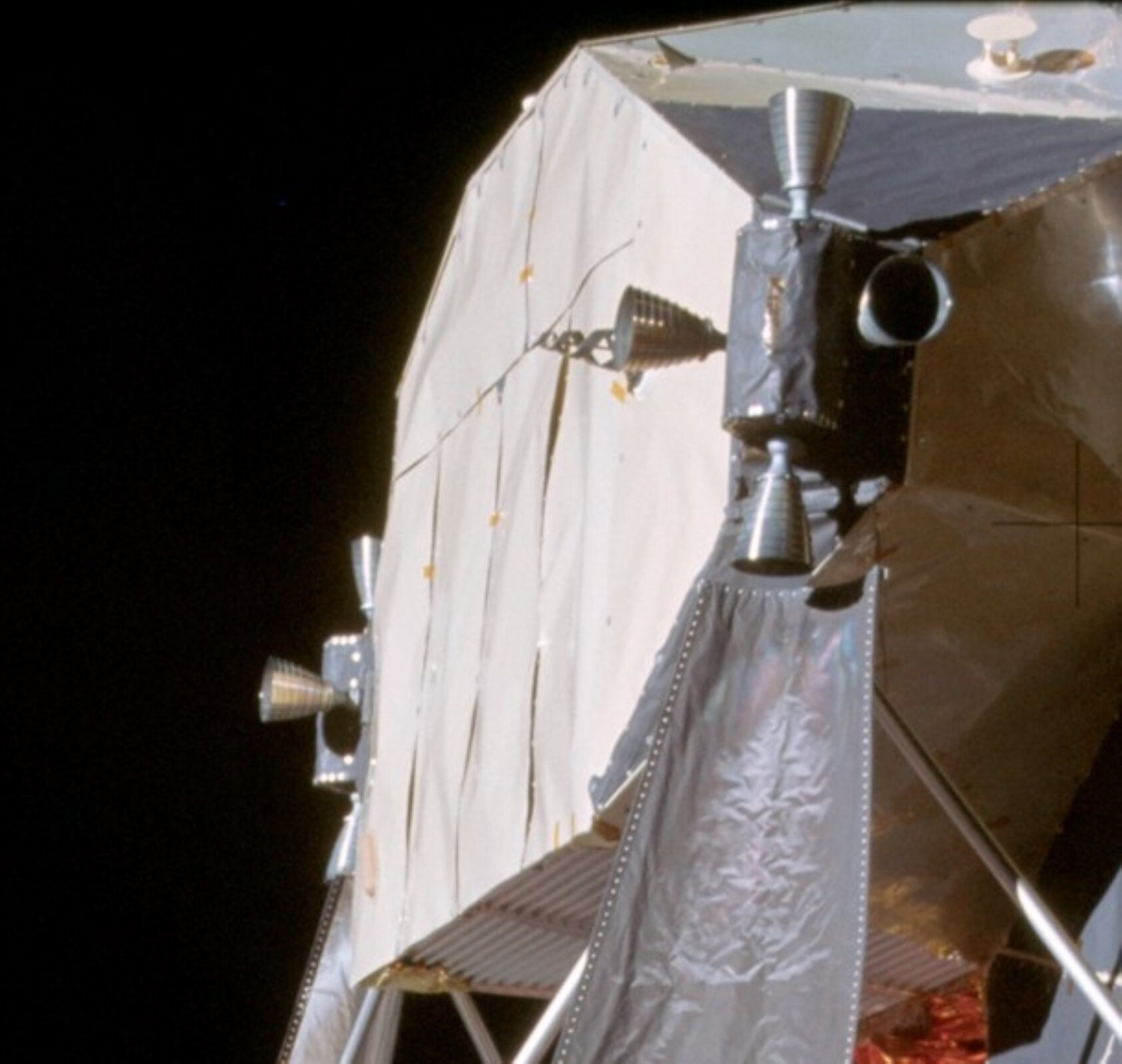 Rys. 2. Zdjęcie przedstawia mały fragment sondy kosmicznej, do której przymocowany jest System Sterowania Reakcyjnego. Jest to element o kształcie zbliżonym do prostopadłościanu, z którego czterech ścian wychodzą w różnych kierunkach cztery dysze.