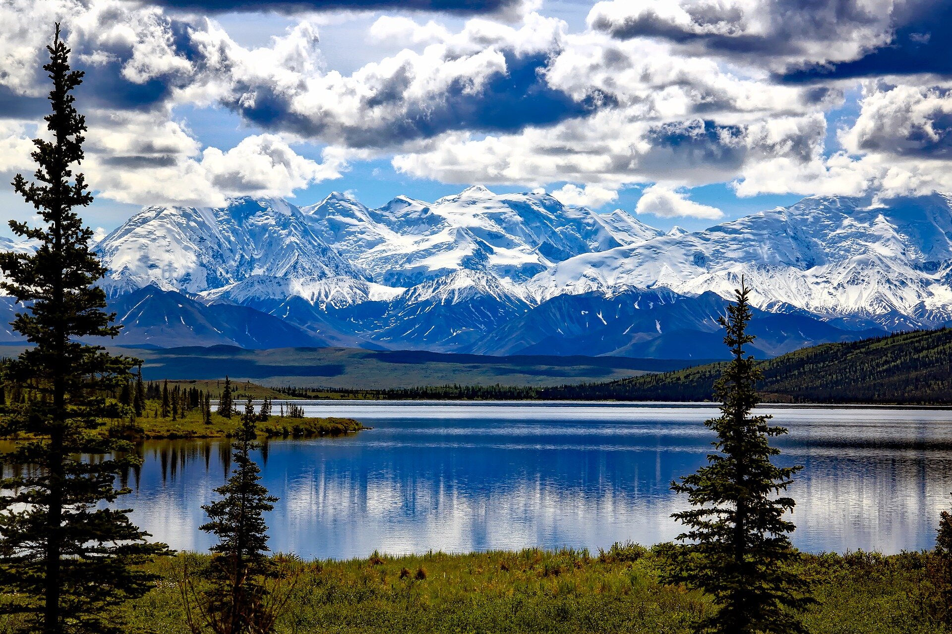 Fotografia przedstawiająca krajobraz gór i jeziora w Parku Narodowym Denali, Alaska, USA. Szczyty gór są pokryte śniegiem.