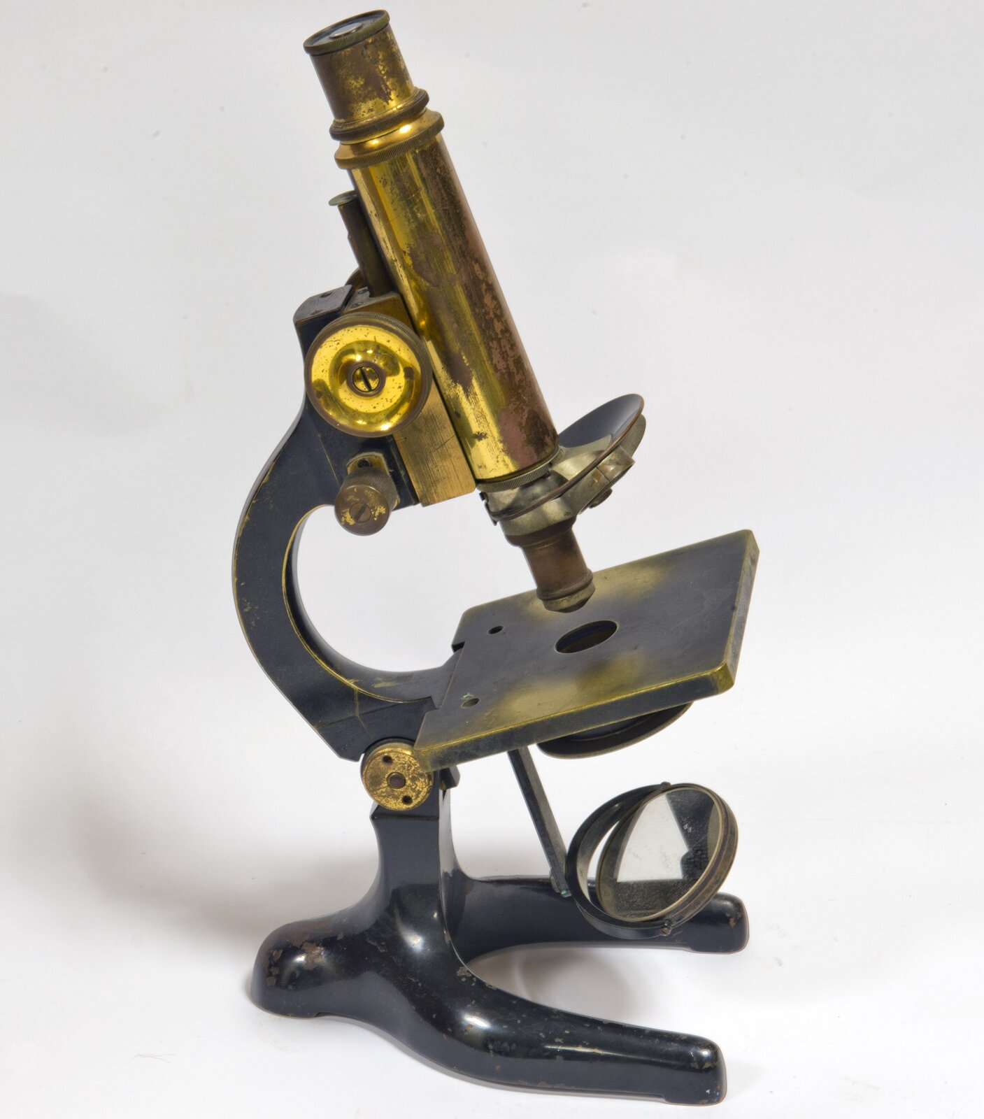 Fotografia przedstawia stary mikroskop. Mimo że jest to przyrząd używany ponad dwieście lat temu, jego budowa jest bardzo zbliżona do współczesnego mikroskopu.