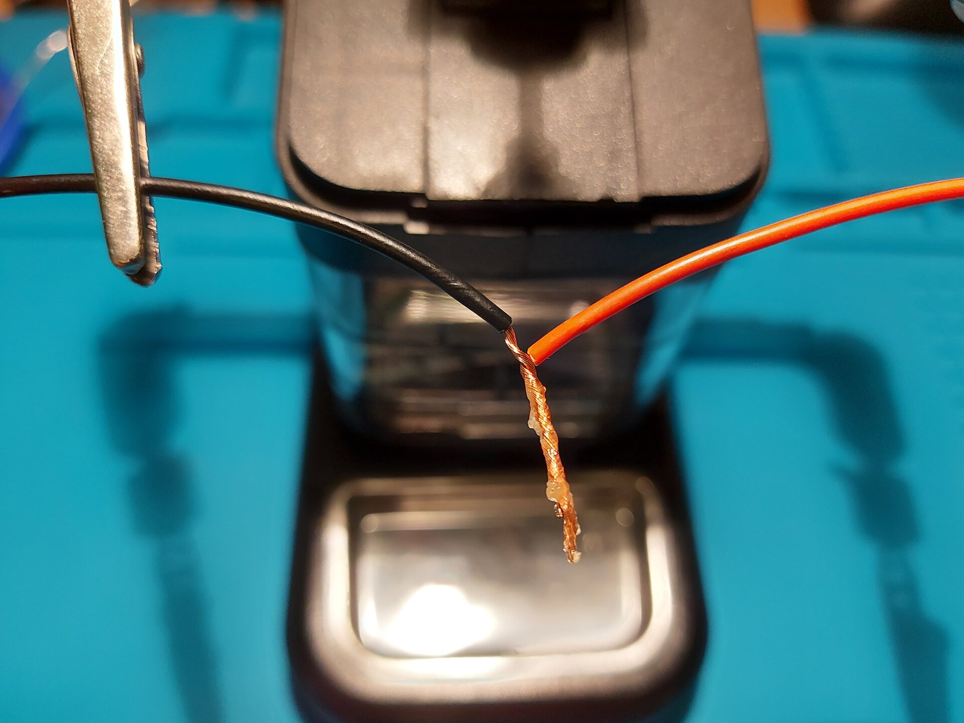 Zdjęcie przedstawia 2 przewody z usuniętą izolacją tym samym odsłaniając miedziane wnętrze, które skręcono ze sobą ustawiając miedziane zakończenia w tym samym kierunku. Na miedziane zakończenia nałożono pastę.