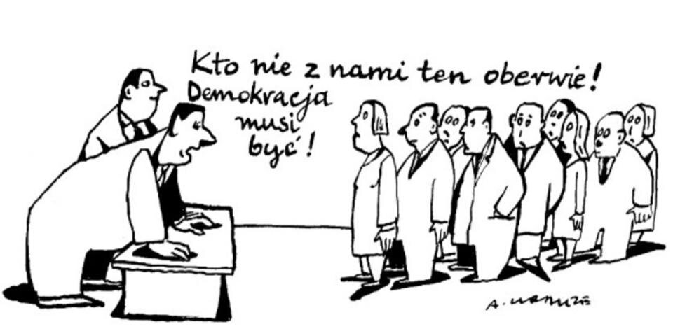 Grafika przedstawia dwóch mężczyzn stojących przy stole, jeden z nich opiera się rękami o stół i mówi "Kto nie z nami ten oberwie! Demokracja musi być!". Przed stołem stoi grupa ludzi i przygląda się mężczyznom.