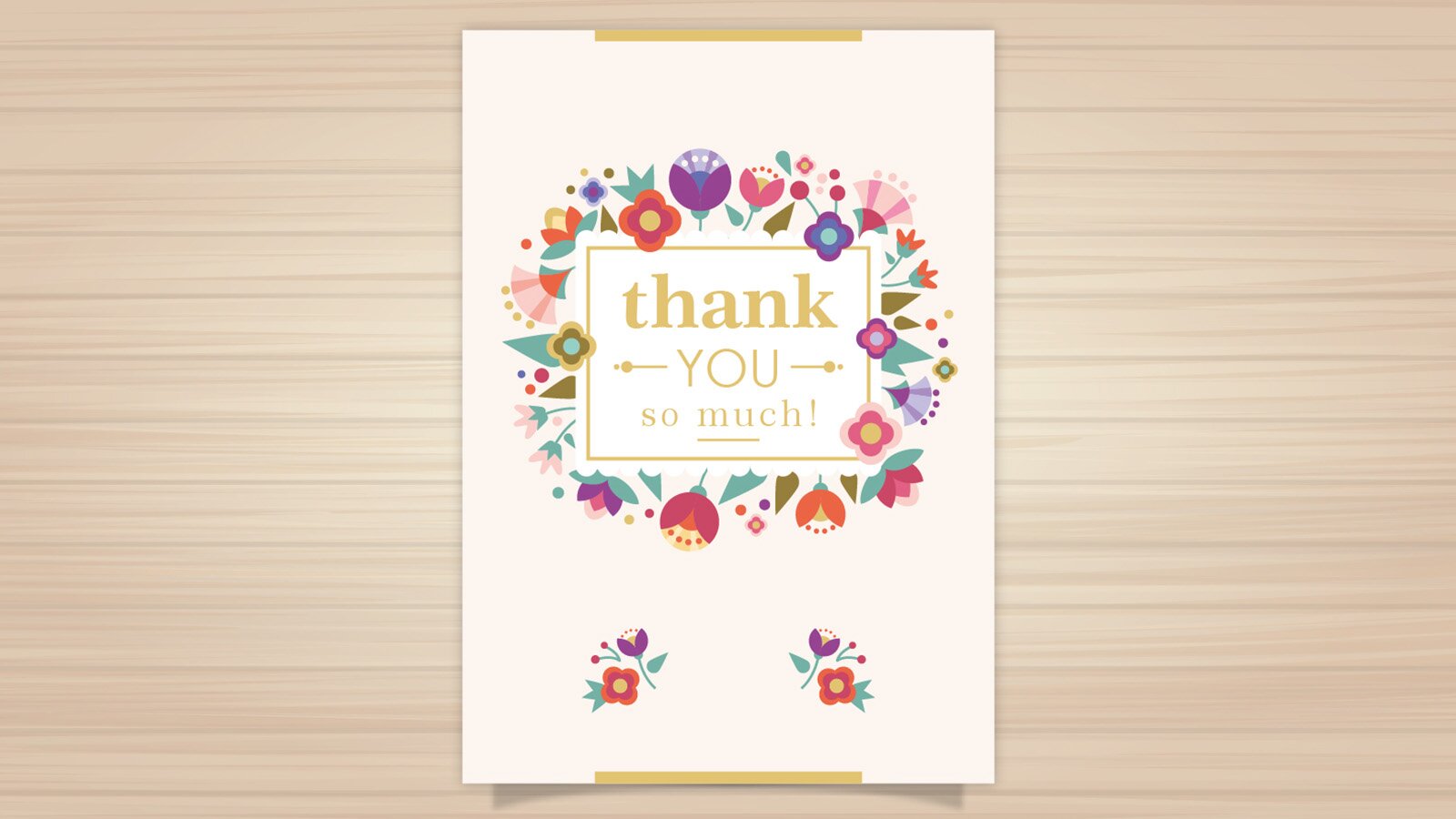 Zdjęcie przedstawia blat, na którym widoczna jest własnoręcznie zrobiona kartka. Na środku karki widoczny jest napis w języku angielskim: THANK YOU SO MUCH. Kartka ozdobiona jest wianuszkiem z kwiatów. 