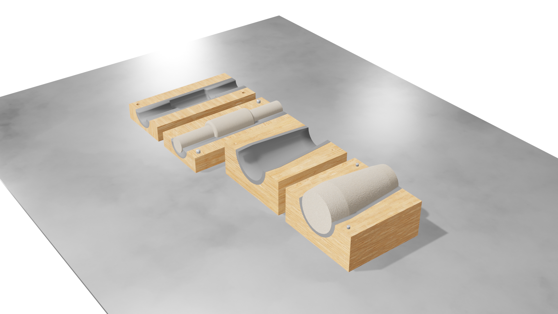 Na zdjęciu widoczny jest animowany model rdzennicy z gotowym rdzeniem.   Na stole położone są cztery drewniane klocki o kształcie prostopadłościanu z wyciętym otworem o przekroju półwalca w górnej jego cześci. W dwóch rdzenniach umieszczone są rdzenie. W rdzennnicy pierwszej od prawej umieszczony jest jeden rdzeń. W drugiej rdzennicy od lewej umieszczone są trzy następujące po sobie krótkie rdzenie. Wszystkie rdzenie są o kształcie walca.