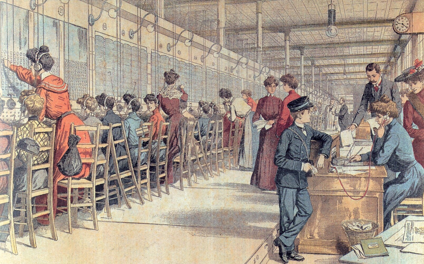 Ilustracja przedstawia centrale telefoniczną, w której kobiety ze słuchawkami na uszach, siedzą przed tablicami z wieloma otworami. Hala centrali jest długa i krzesła z pracującymi kobietami stoją wzdłuż całej jednej ściany.  Na przeciwko przy biurkach siedzą inni pracownicy odbierający telefony stojące na biurkach.