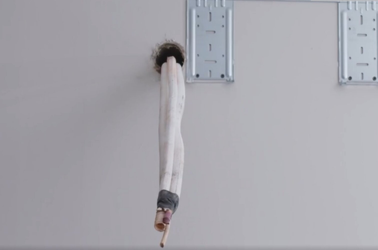 Zdjęcie przedstawia wiązkę rur i przewodów przełożoną przez przepust w ścianie.
Opisy prezentowanych na grafikach obiektów są załączone w treści.