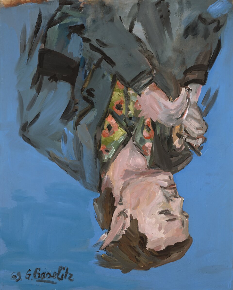 Na ilustracji znajduje się obraz Georga Baselitz, „Portret Franza Dahlema”. Na obrazie znajduje się odwrócony do góry nogami portret mężczyzny o brązowych włosach. Mężczyzna ma na sobie kolorową koszulę oraz ciemną marynarkę. Widoczne są wyraziste, nasycone barwy (niebieskie tło, na którym znajduje się postać), a także silny kontrast między ciemnymi i intensywnymi kolorami a jasnymi odcieniami. Pociągnięcia pędzla są wyraziste. 