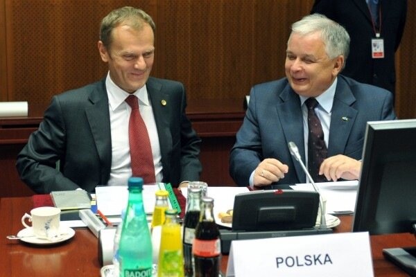 Zdjęcie przedstawia Prezydenta Lecha Kaczyńskiego i Premiera Donalda Tuska, którzy uczestniczą w posiedzeniu. Przed nimi stoi tabliczka z opisem kraju, z którego pochodzą: POLSKA.