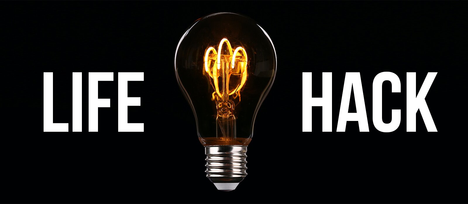 Grafika przedstawia palącą się żarówkę na czarnym tle. Po lewej stronie widoczny jest  napis w języku angielskim:  LIFE, a po prawej napis w języku angielskim:  HACK.
