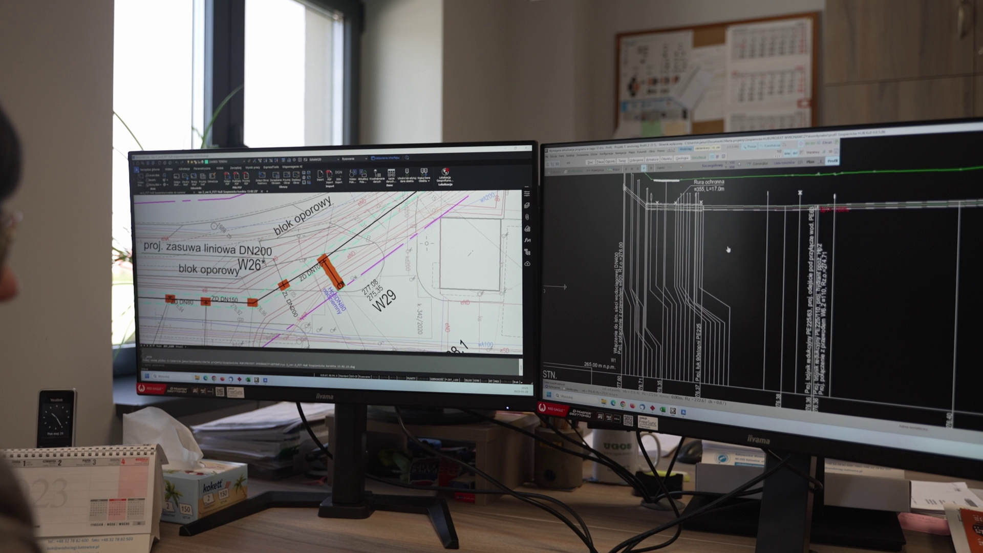 Grafika przedstawia projektowanie rurociągu za pomocą programów komputerowych. Na dwóch monitorach pokazane są fragmenty powstającego projektu.