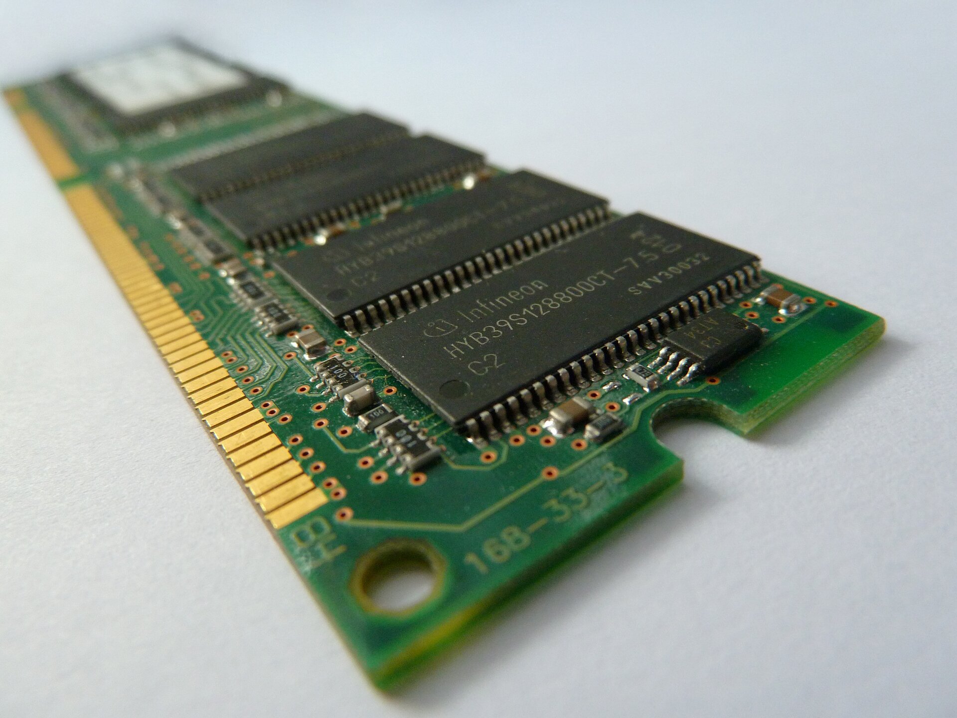 Zdjęcie przedstawia pamięci RAM. Jest to podłużna, prostokątna płytka PCB zawierająca czarne, prostokątne układy pamięci.  Na jej spodzie znajdują się piny służące do komunikacji z innymi podzespołami komputera.