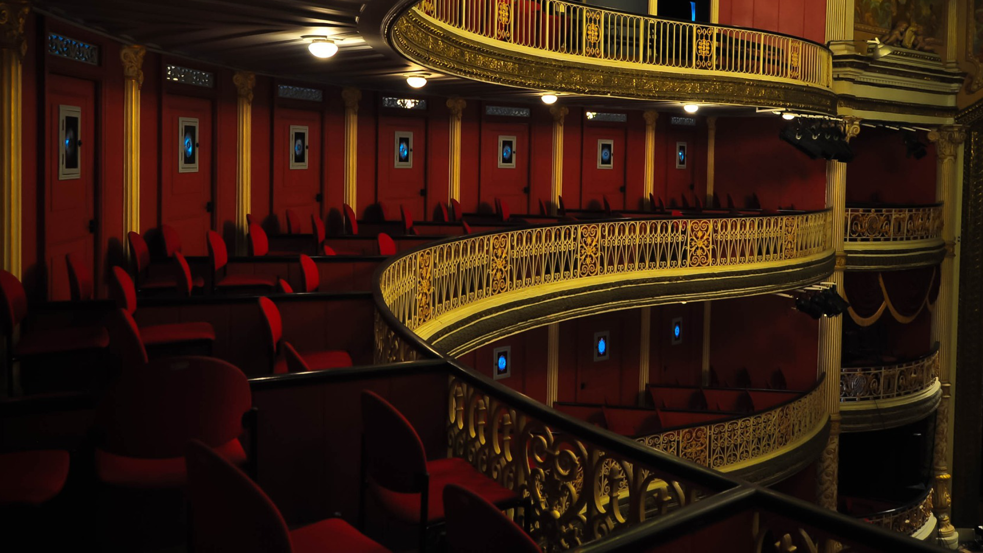 Na zdjęciu znajdują się trzy poziomy balkonów teatralnych. Na każdym z nich widoczne są wygodne fotele dla publiczności i dekoracyjne balustrady. Balkony są puste. 