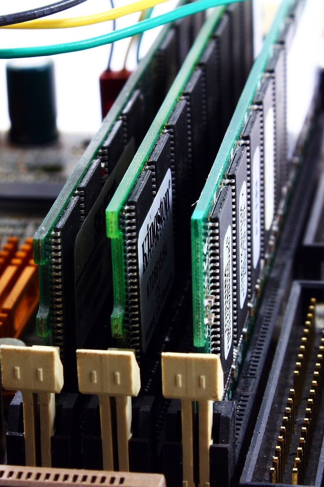 Fotografia przedstawiająca trzy moduły pamięci SD RAM zamontowane na płycie głównej w slotach D I M M. Jedna z nich to Kingston KTC6615/64 . 