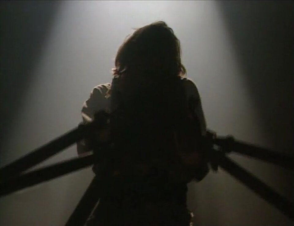 Zdjęcie przedstawia kadr z filmu. Znajduje się na nim postać Winkelrieda, w którego skierowane są ostrza broni. Postać mężczyzny jest ocieniona, podświetla ją od tyłu snop światła.