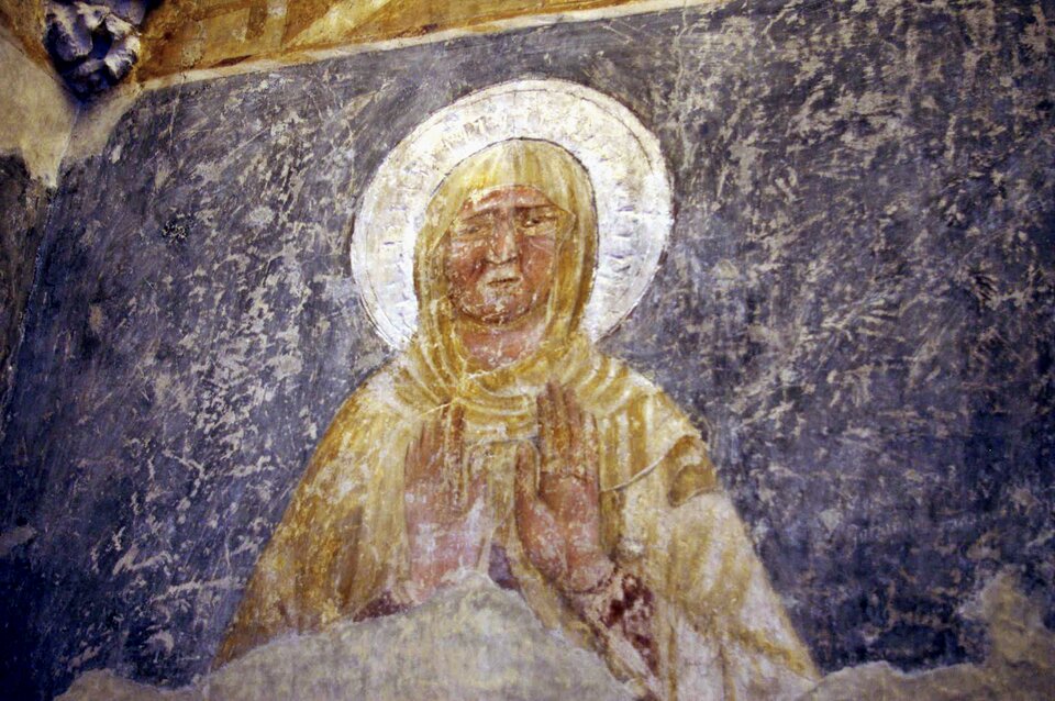 Ilustracja przedstawia malowidło ścienne z II poł. XIV wieku w  Niepołomicach. Ukazuje modlącą się kobietę na niebieskim tle. Postać ma wyciągnięte przed sobą dłonie na znak modlitwy, Ubrana jest w żółtą szatę , a jej głowę otacza nimb. Można ją odczytać jako Matkę Boską. 