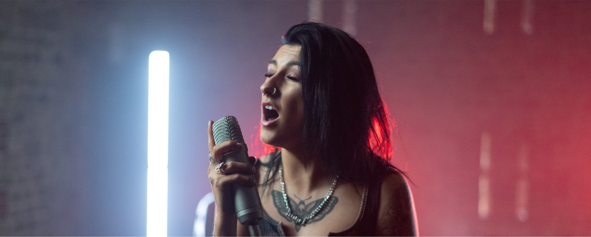 Zdjęcie przedstawia piosenkarkę z mikrofonem w ręku..
