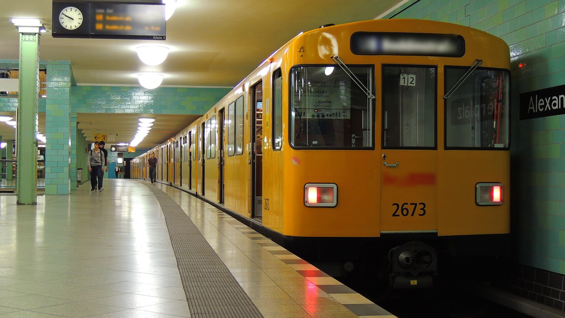 Zdjęcie przedstawia metro stojące na stacji w tunelu. Każde drzwi kolei są otwarte. Przekrój poprzeczny metra jest kwadratem. Metro nie posiada podziału na wagony, przez co jest jednoczłonowym pojazdem.