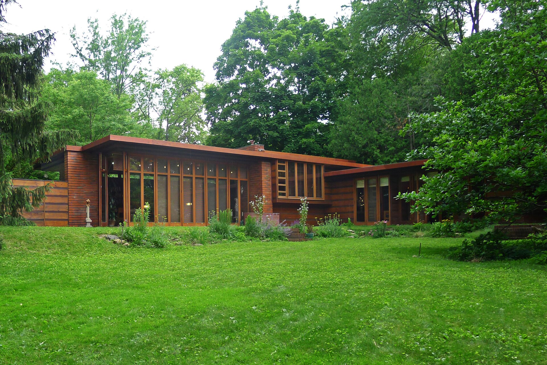 Ilustracja o kształcie poziomego prostokąta przedstawia przykład domu usonijnego - pierwszy dom Herberta i Katherine Jacobsów zaprojektowany przez Franka Lloyda Wrighta. Dom o drewnianej  konstrukcji opartej na szkielecie został usytuowany na tle zieleni, pośród drzew. Jest niski i rozłożysty. Posiada wiele dużych okien. 
