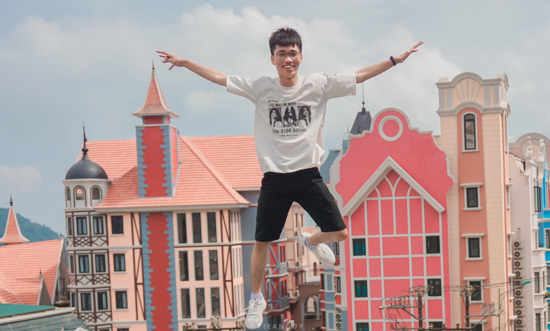 Zdjęcie przedstawia chłopca, który podskakuje. W oddali widać panoramę miasta.