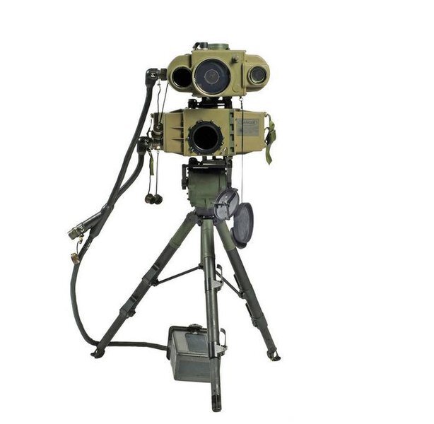 Na zdjęciu znajduje się dalmierz laserowy. Dwa urządzenia wyposażone w obiektywy ustawione są na trójnogim statywie. Pierwsze urządzenia ma obły, pociągły kształt. Ma jeden duży obiektyw i dwa mniejsze rozmieszczone po bokach. Pod nim znajduje się drugie urządzenie. Ma prostokątny kształt oraz jeden obiektyw ustawiony na środku. Urządzenia połączone są przewodem, który prowadzi do prostokątnego pudełka ustawionego w dolnej części dalmierza.