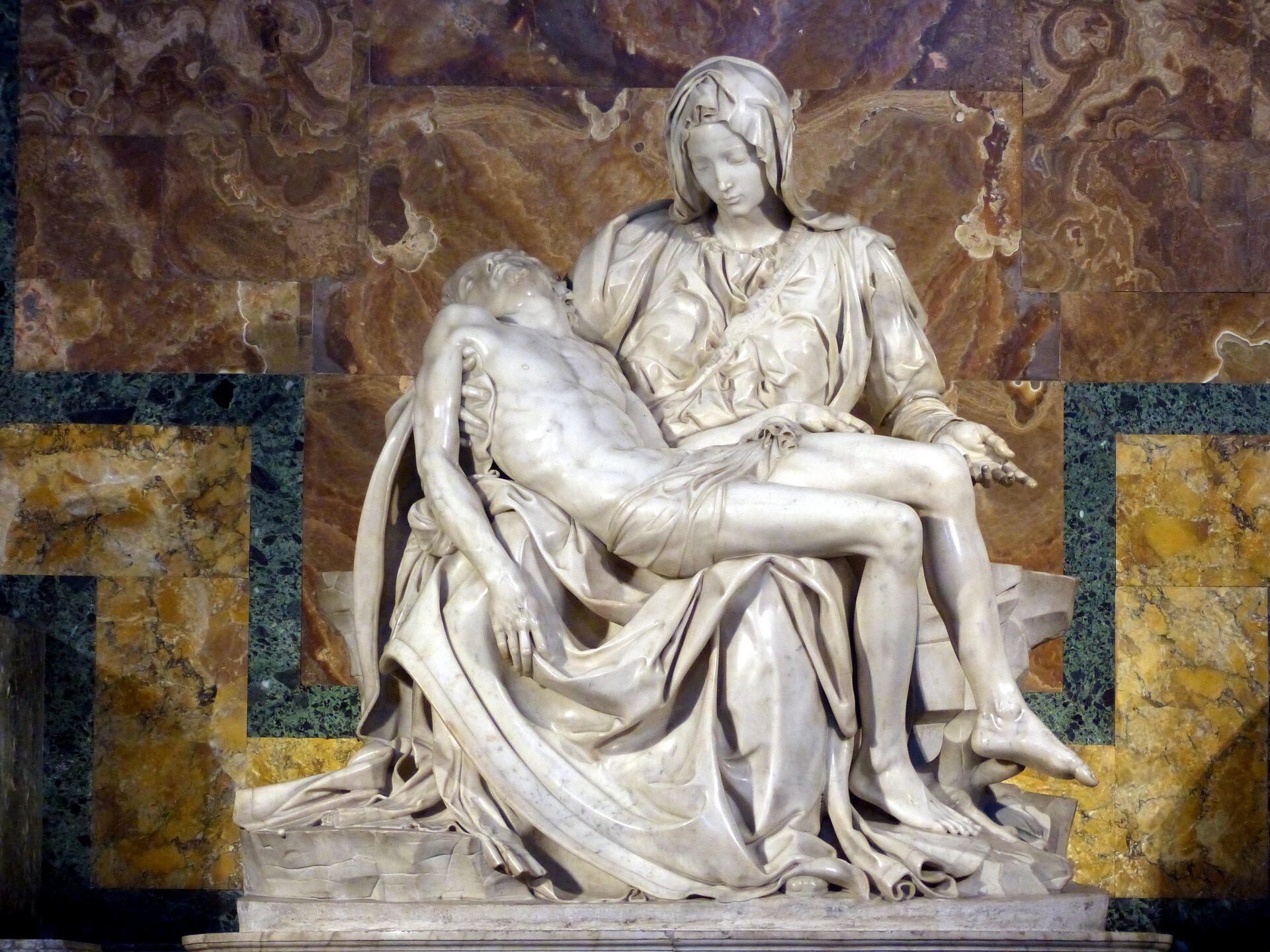 Na zdjęciu rzeźba, która przedstawia Maryję trzymającą w ramionach zdjętego z krzyża Jezusa. Trzyma Go na kolanach. Konstrukcja dzieła ma kształt piramidy, której wierzchołek stanowi głowa Marii. Rzeźba rozszerza się stopniowo w dół, aż do samej podstawy, na której rozpościera się szata. Postacie nie są proporcjonalne ze względu na trudności z przedstawieniem dorosłego mężczyzny trzymanego na kolanach kobiety. Postać Madonny jest ukryta pod fałdami szat, przez to wspomniana dysproporcja nie rzuca się w oczy i figury wyglądają naturalnie. Ślady po ukrzyżowaniu są ograniczone do niewielkich ran po gwoździach na ręce Jezusa i zaznaczenia rany w boku Jezusa. Ślady po gwoździach w stopach nie przechodzą „na wylot” do zewnętrznej części stóp. Madonna jest przedstawiona jako bardzo młoda kobieta. Na piersi Marii szarfa, a tam mało widoczny napis "MICHAEL ANGELUS BONAROTUS FLORENT FACIBAT" (tłum.: uczynił to Florentczyk, Michał Anioł Buonarroti). 