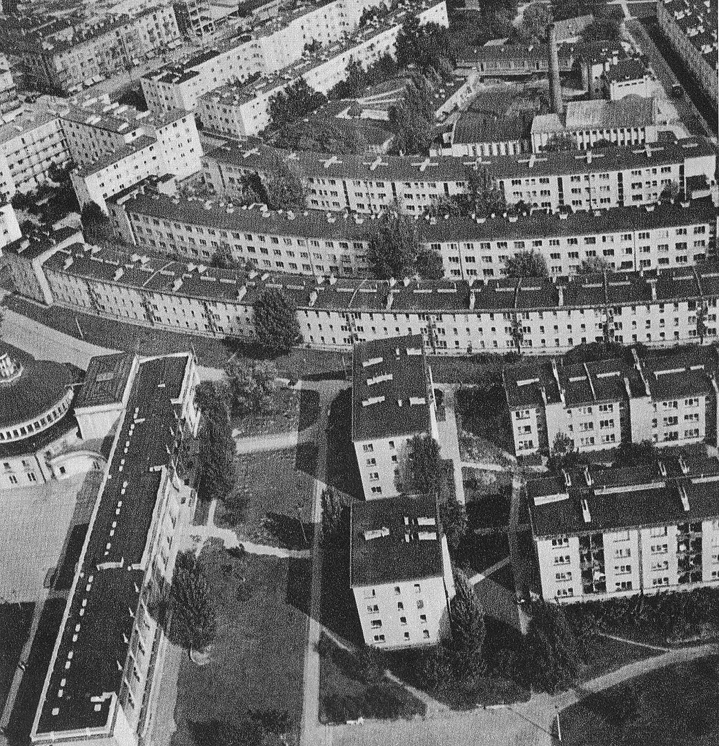 Zdjęcie przedstawia zabudowę miejską z lotu ptaka. Widać na nim liczne dwupiętrowe bloki stojące jeden obok drugiego.