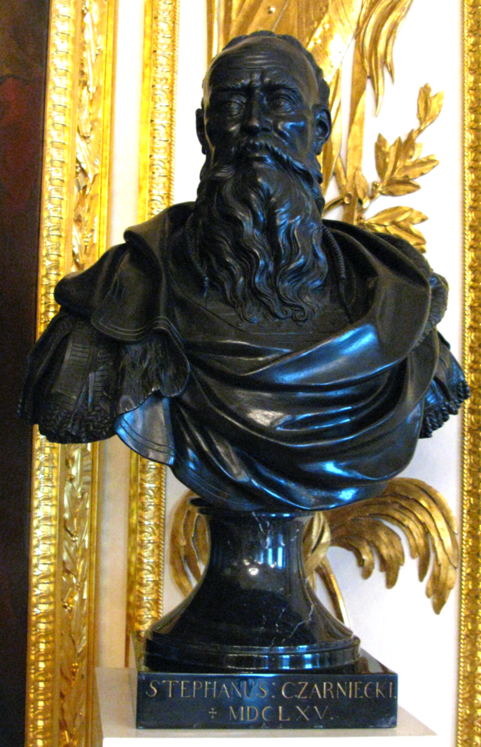 Na zdjęciu znajduje się popiersie Stefana Czarnieckiego z Sali Rycerskiej na Zamku Królewskim w Warszawie z napisem informacyjnym u podstawy. Wykonana w marmurze sylwetka jest silnie udrapowana dla oddania charakteru modela. Czarniecki jest starcem z długą, kędzierzawą brodą. Jego głowa jest silnie wygolona, a szaty przywołują antyczną togę. 