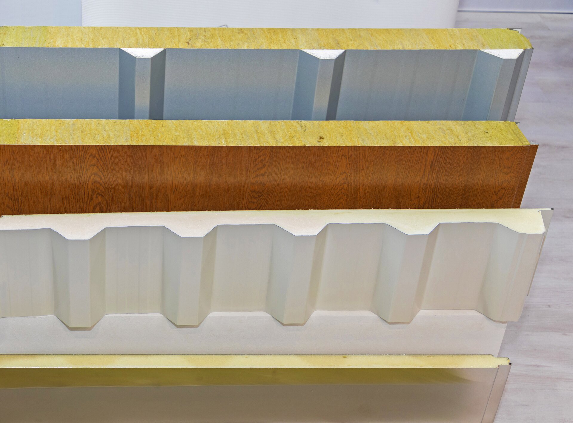 Zdjęcie przedstawia kilka płyt typu sandwich, które składają się z jasnożółej poliuretanowej pianki oraz drewnianej wykładziny wykonanej ze sklejki.