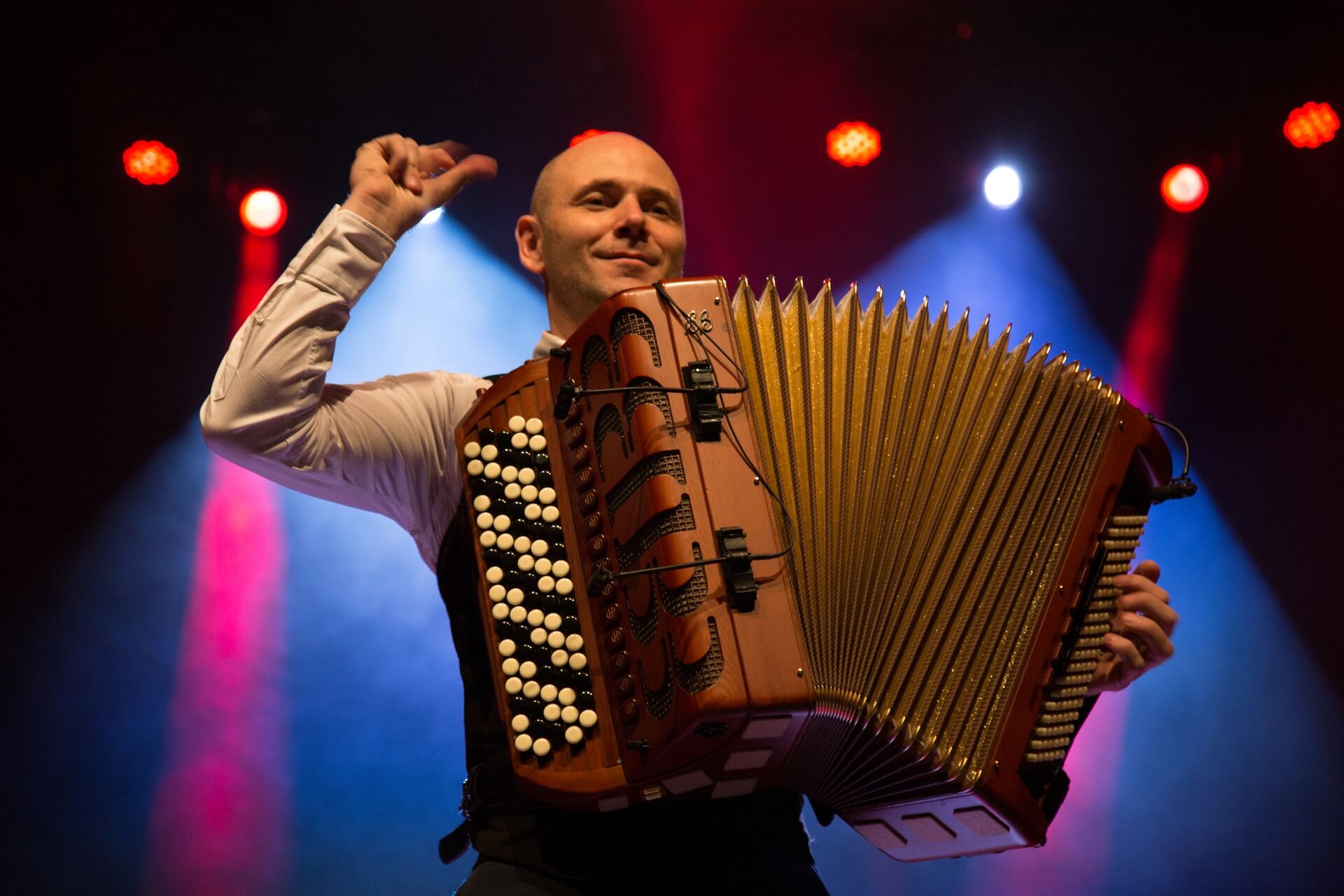 Na zdjęciu zaprezentowany został łysy mężczyzna mający około czterdzieści lat, ubrany w białą koszulę. Jego twarz zdobi uśmiech, a prawą rękę ma ugiętą i pstryka palcami do rytmu muzyki. Drugą ręką podtrzymuje swój akordeon, który przesłania praktycznie całą jego klatkę piersiową. Z tyłu na ciemnym tle biją światła reflektorów.  