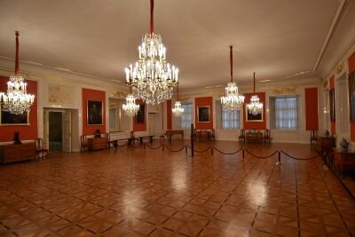 Ilustracja przedstawia nową Izbę Poselską na Zamku Królewskim w Warszawie. Jest ona obszerna z rozwieszonymi diamentowymi żyrandolami. 