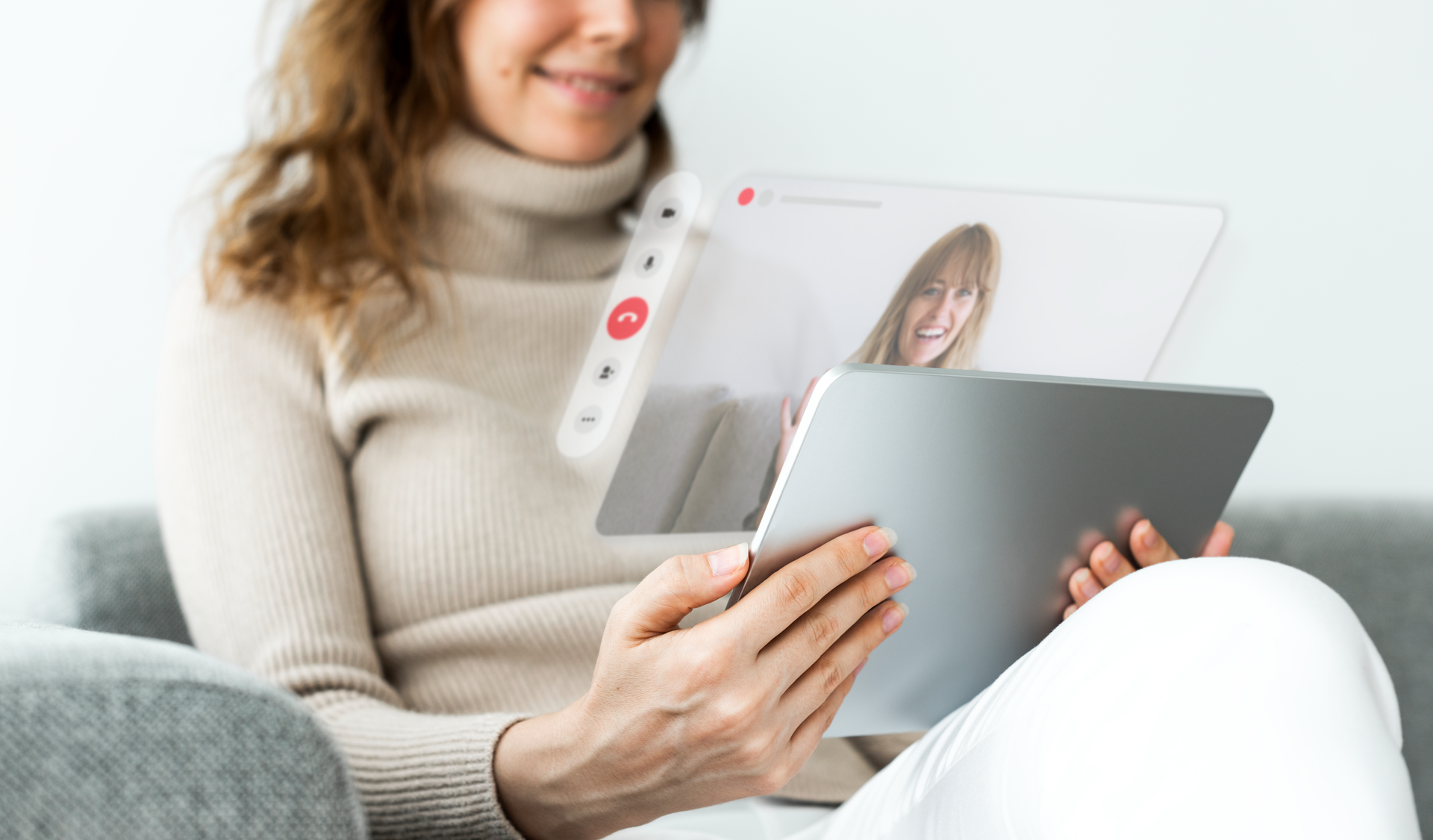 Zdjęcie przedstawia dziewczynę, która siedzi na sofie i w rękach trzyma tablet i prowadzi z kimś rozmowę.