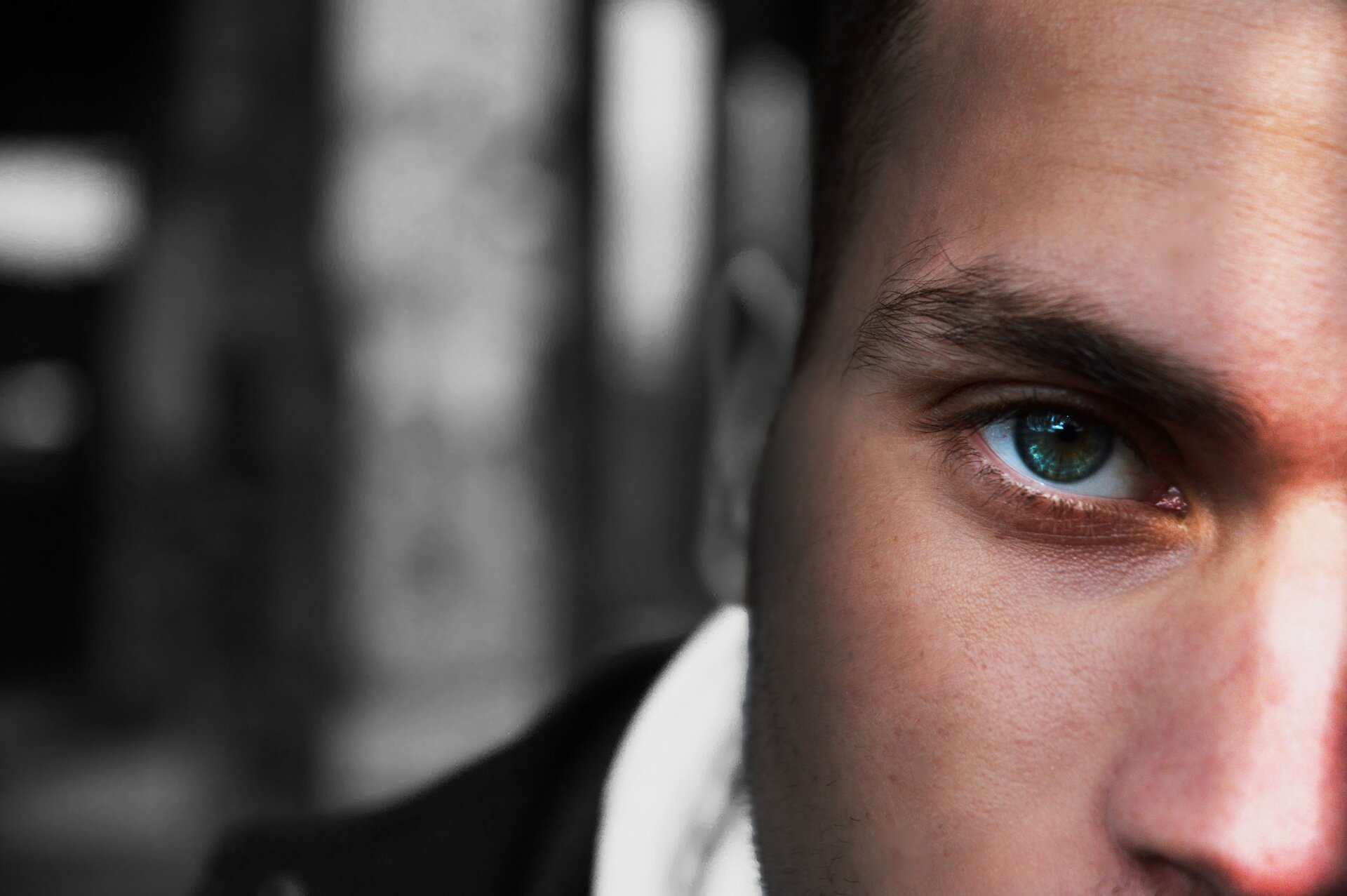 Kliknij, aby powiększyć. Zdjęcie przedstawia bardzo duże zbliżenie na połowę twarzy mężczyzny.