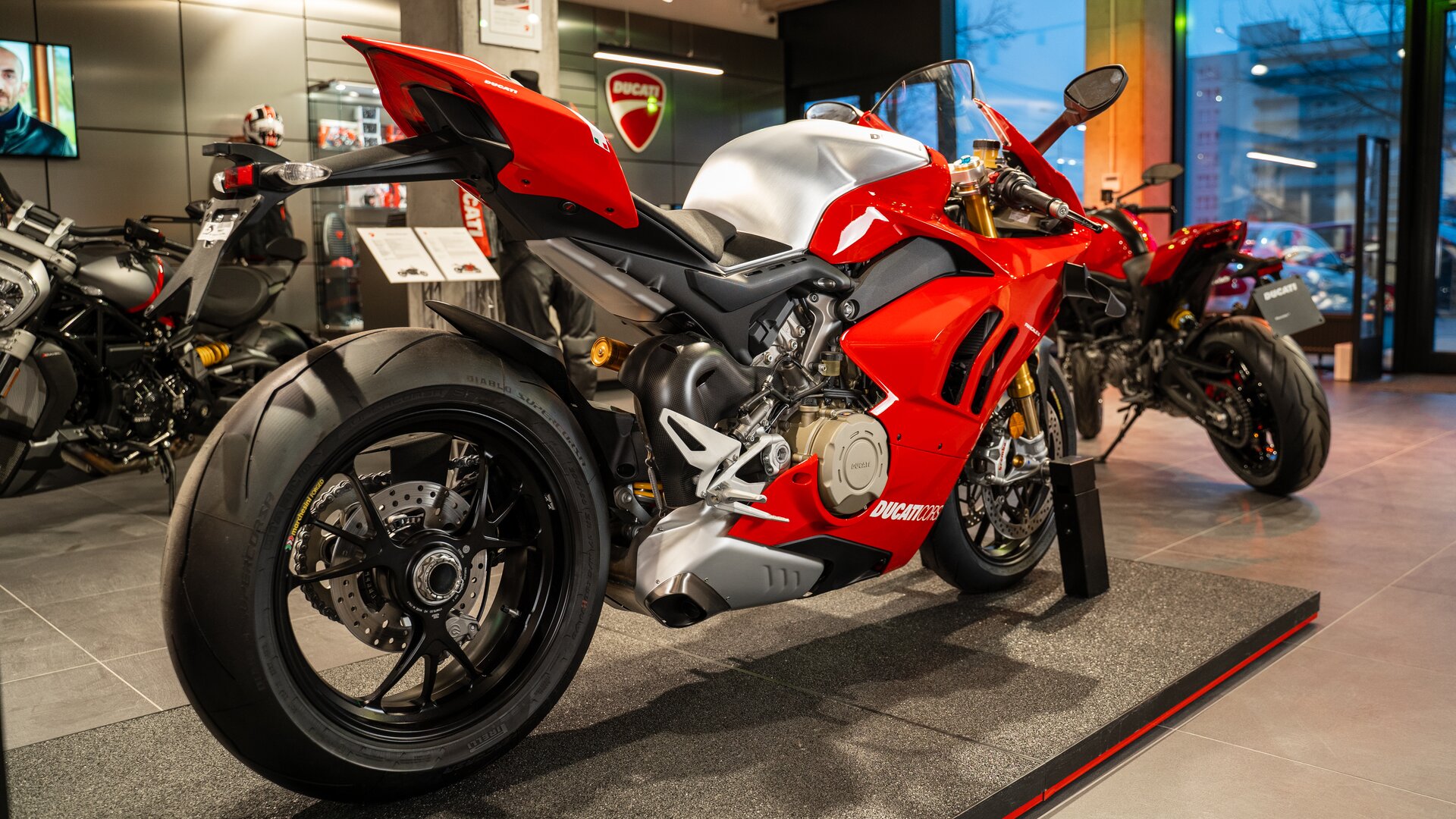 Zdjęcie przedstawia motocykl. Znaczna część motocykla jest obudowana czerwoną karoserią. Jest masywny. Tył motocykla, błotnik,  jest znacznie powyżej tylnego koła. 