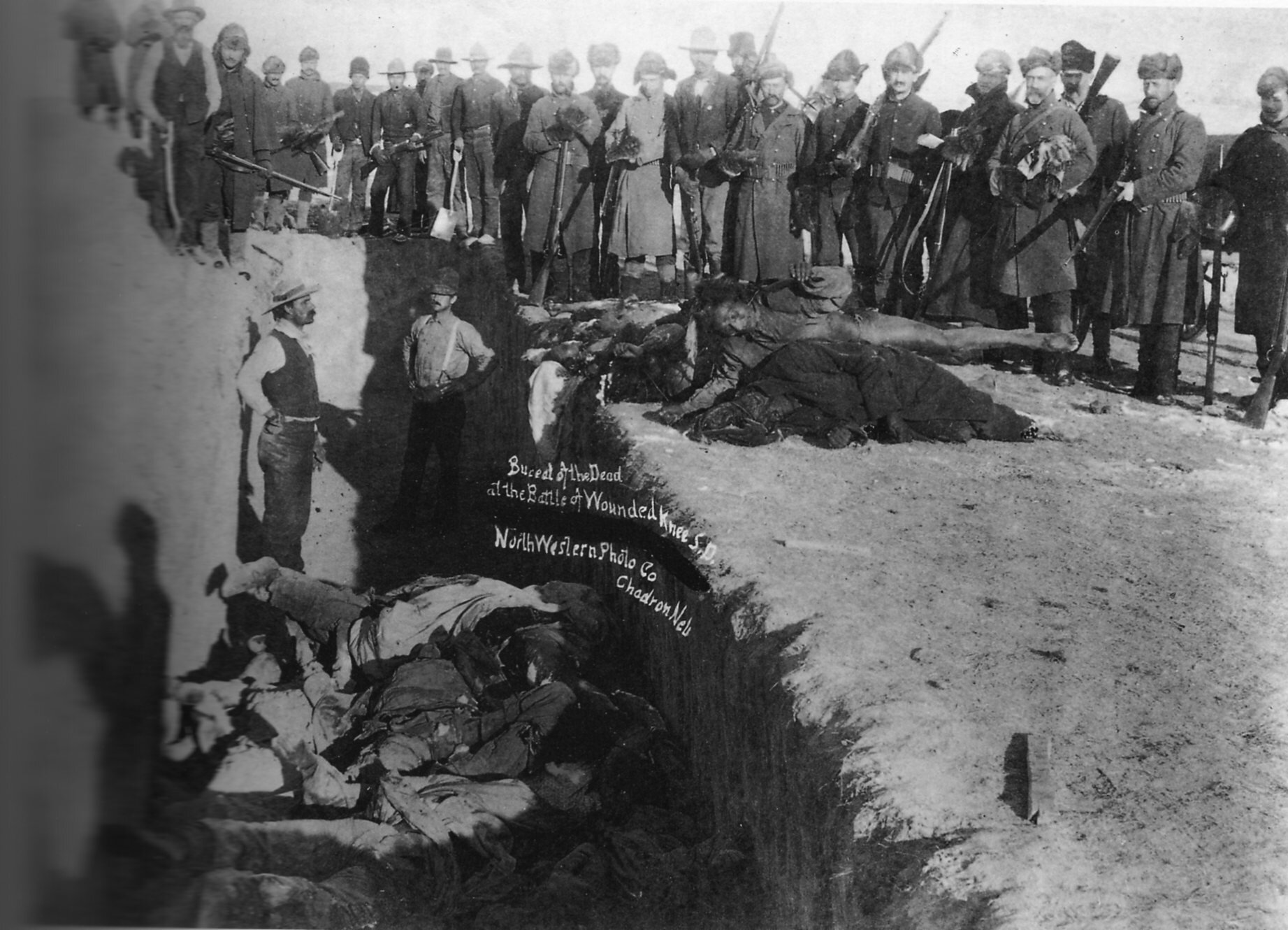 Fotografia czarno-biała przedstawiająca pogrzeb zmarłych po masakrze Wounded Knee.