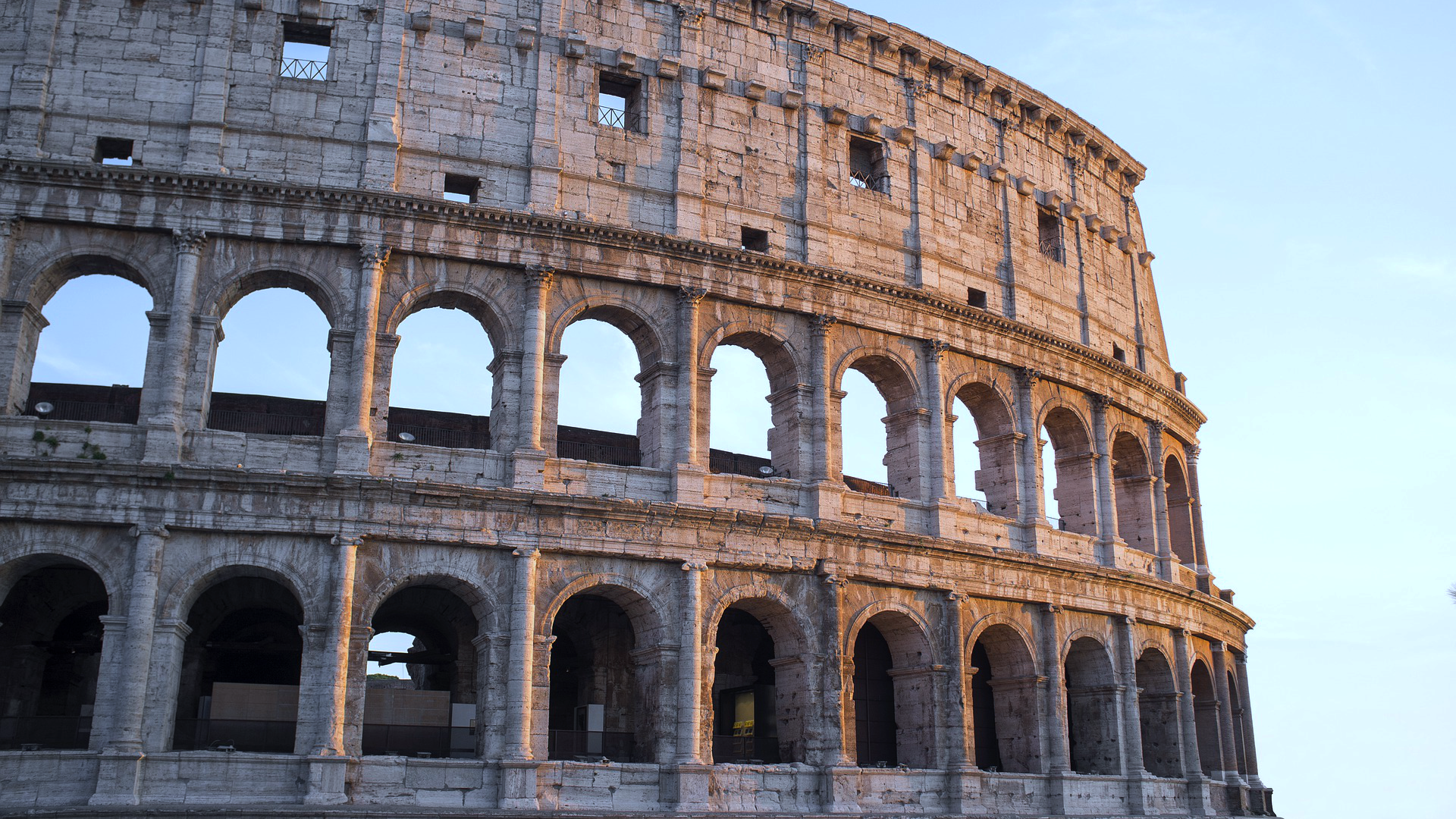 Zdjęcie przedstawia Koloseum w Rzymie. Widoczny jest fragment murów. 