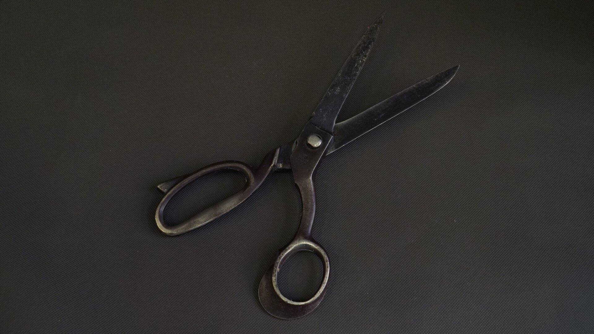 Na zdjęciu ukazano nożyce, które składają się z dwóch ostrzy połączonych ze sobą na wspólnej osi z uchwytami na palce po przeciwnej stronie.