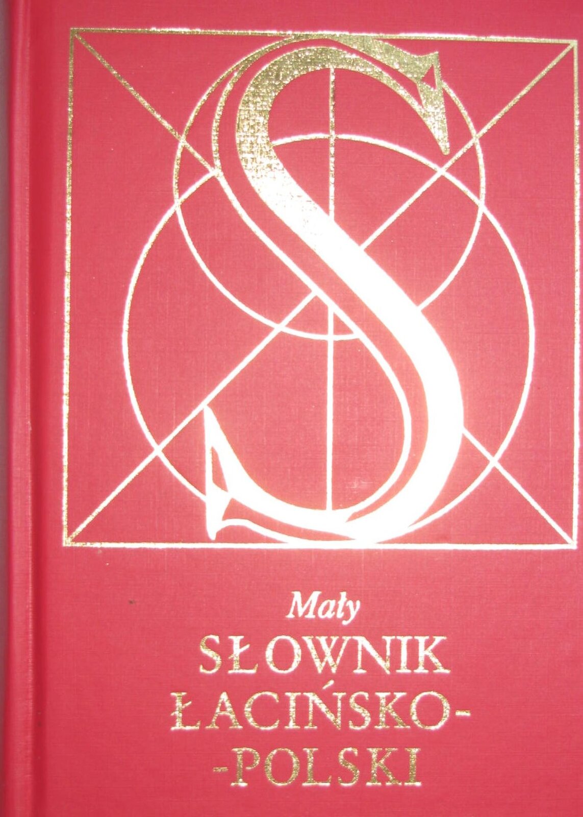Fotografia nieznanego autora przedstawia widok na stronę tytułową Słownika łacińsko-polskiego pod redakcją Józefa Korpantego. Okładka została wykonana z czerwonego grubego papieru o lekko chropowatej fakturze. Na okładce znajduje się ilustracja:  Złota litera S zawarta w dwóch okręgach, które znajdują się w kwadracie. Pod ilustracją widoczny jest napis Mały SŁOWNIK ŁACIŃSKO-POLSKI.