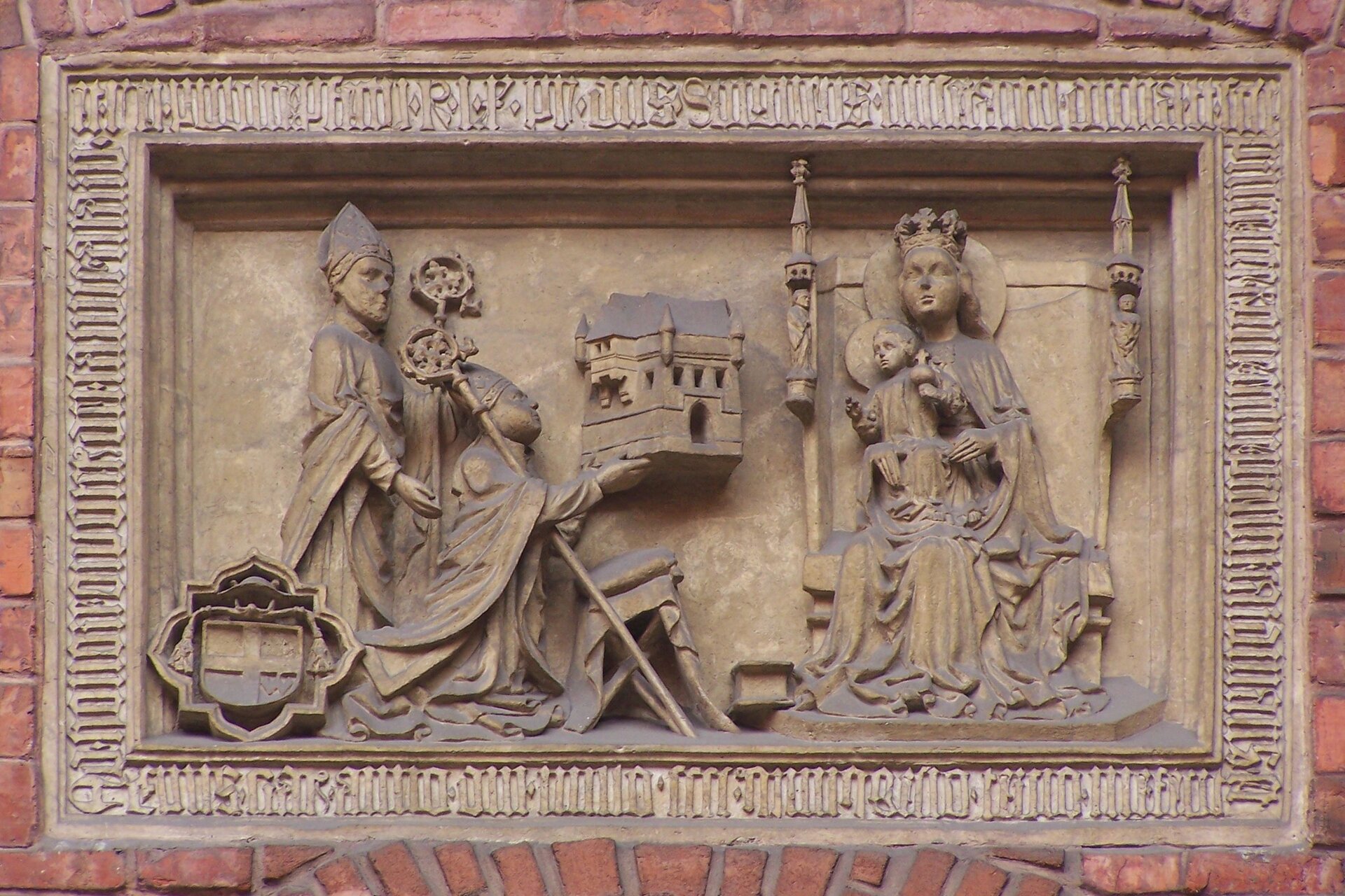 Fotografia nieznanego autora przedstawia płaskorzeźbę ukazującą cztery osoby – Zbigniewa Oleśnickiego i biskupa oraz Maryję z dzieciątkiem. Zbigniew Oleśnicki stoi obok klęczącego biskupa, który wręcza Marii bursę Uniwersytetu Jagiellońskiego. Maryja siedzi z dzieciątkiem na tronie, nie patrzy na biskupa, ma kamienny wyraz twarzy. Dzieciątko z zainteresowaniem patrzy w stronę fundatora bursy.