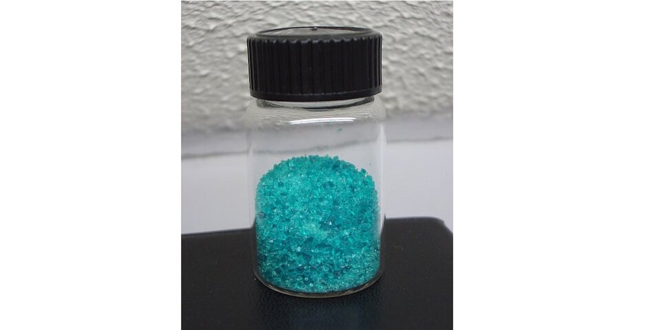 Na zdjęciu w zakręconej butelce są drobne, niebieskie kryształy.