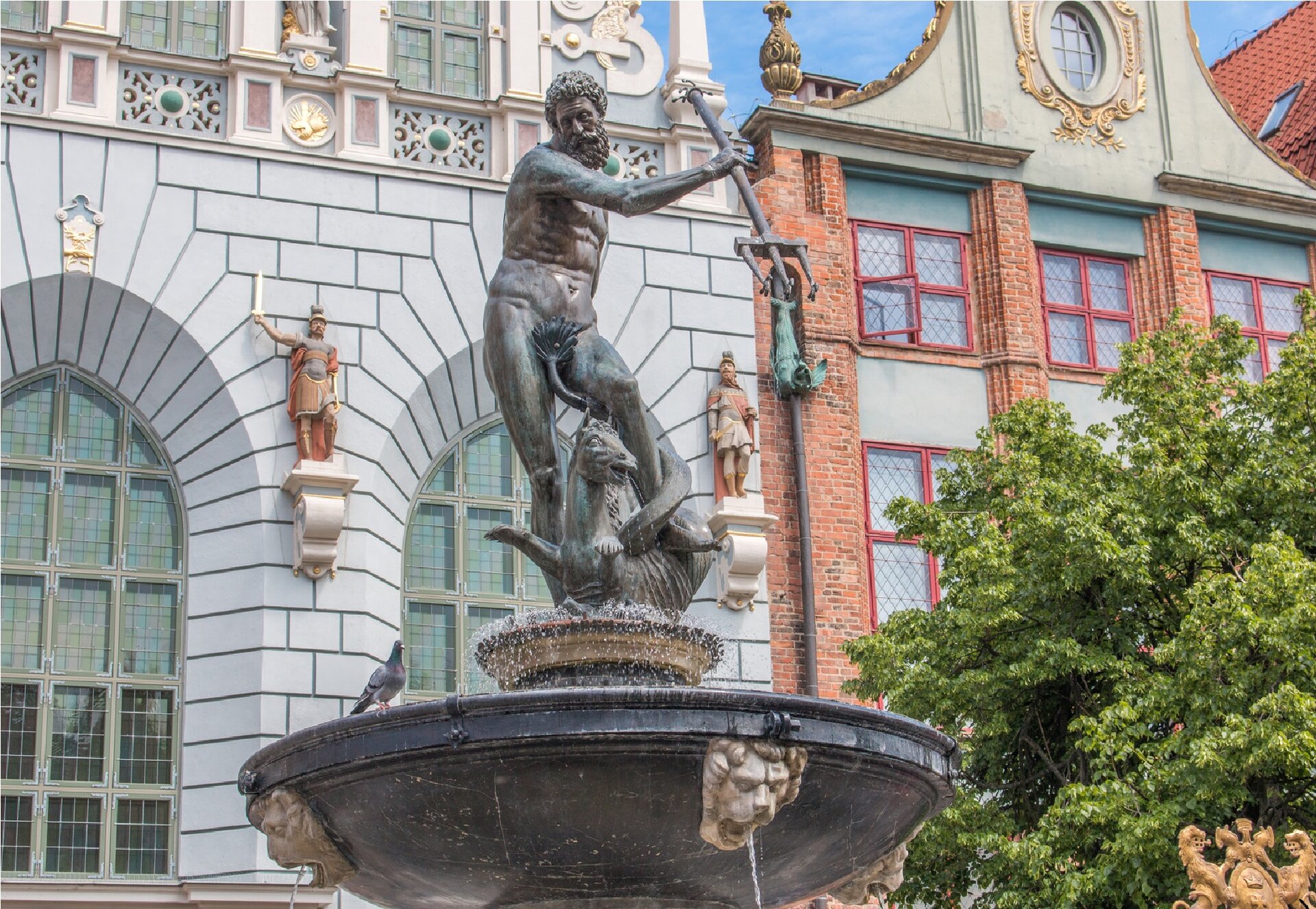 Ilustracja przedstawia Fontannę Neptuna w Gdańsku. W centrum fontanny ustawiona jest rzeźba z brązu ukazująca nagiego, brodatego mężczyznę z trójzębem w prawej, wysuniętej do przodu ręce. Władca mórz został ukazany podczas walki z końmi morskimi, które wiją się u jego stóp. Dynamicznie przedstawiona postać została wykonana z dużą dbałością o detal. Na jego ciele z pieczołowitością wyrzeźbiono każdy mięsień. Pod rzeźbą znajduje się górna, czarna misa fontanny z jasnymi głowami lwów, z których leje się woda. Posąg ukazany został na tle kamieniczek.