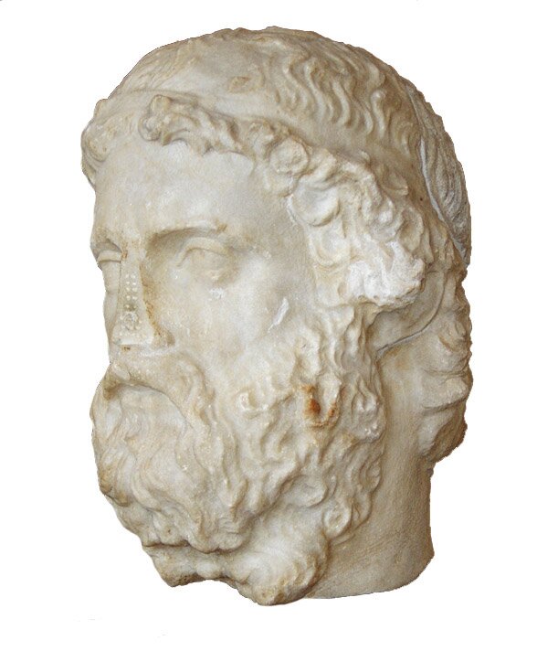 Zdjęcie przedstawia wykonaną z białego kamienia rzeźbę głowy Anakreonta. Mężczyzna ma kręcone włosy, wąsy i okazałą, kręconą brodę. Rzeźba jest uszkodzona – postaci brakuje nosa. Tło jest białe.