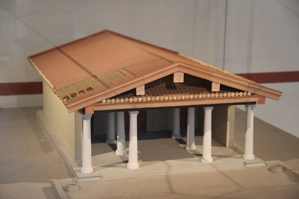 Model świątyni etruskiej, zbudowanej na kamiennym fundamencie (podium), z dwuspadowym dachem. Jest to prostokątna bryła,  z wysokim i głębokim przedsionkiem wspartym na dwóch rzędach kolumn oraz z trzema wejściami do pomieszczeń w tylnej części bryły. Przy krawędzi dachu, nad przedsionkiem umieszczone dekoracje z płaskorzeźb. 