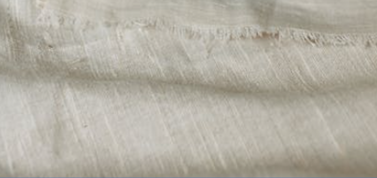 Na zdjęciu widoczny fragment materiału w kolorze beżowo‑szarym. Nagranie tożsame z treścią.