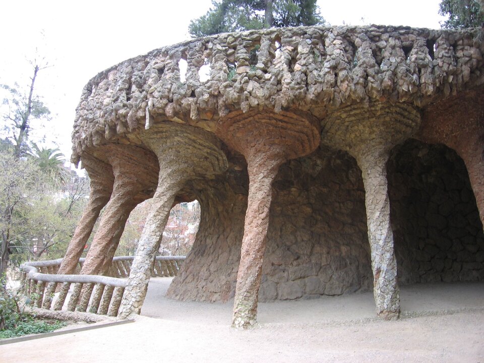 Ilustracja przedstawia pracę Antonio Gaudi pt. „Park Güell”. Dzieło pochodzi z 1922 roku. Park znajduje się w Barcelonie w Hiszpanii. Na fotografii został przedstawiony fragment budowli znajdującej się w parku. Widoczne są liczne, kamienne kolumny oraz znajdujący się nad nimi taras.