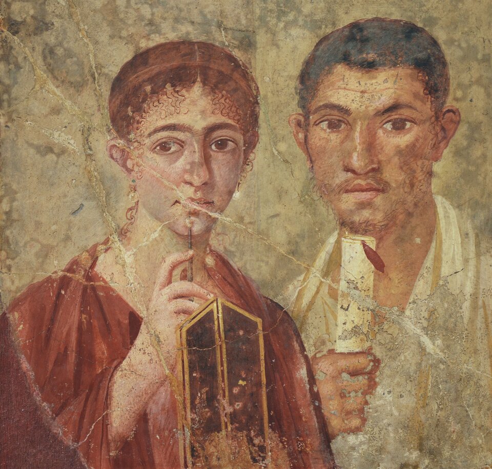 Dwie postaci uchwycone na fresku. Po lewej stronie kobieta w tradycyjnym stroju kobiecym rzymskim w kolorze bordowym. Swoją prawą dłoń podtrzymującą stylo kieruje ku brodzie. Przed nią widoczna rama dwóch tabliczek woskowych, grzbietem zwrócona w kierunku widza. Po jej prawej stronie mężczyzna o ciemniejszej karnacji i włosach, lekko cofnięty. W swojej lewej ręce podtrzymuje papirus z przywieszonym czerwonym piórem. Papirus trzyma pionowo pod brodą, lewą dłoń trzyma na wysokości torsu. 