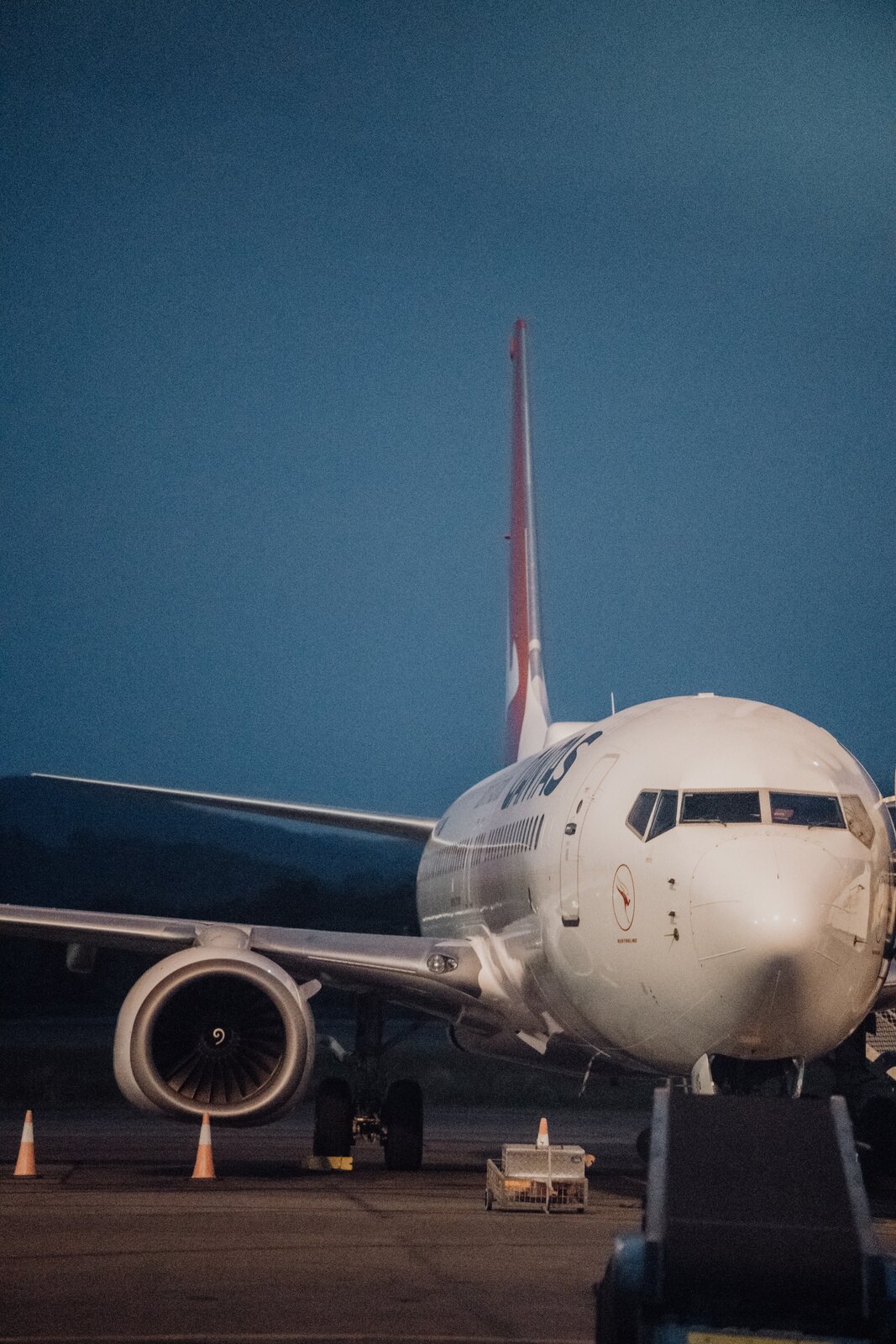 Zdjęcie przedstawia dziób i fragment kadłuba i prawego skrzydła samolotu. Samolot w kolorze białym stoi na płycie lotniska. Widoczny jest z przodu, od strony kokpitu pilota.