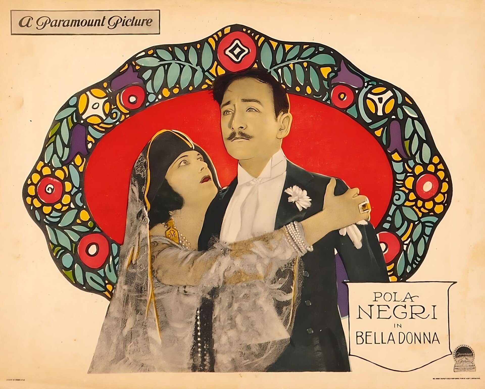 Na ilustracji plakat do filmu Poli Negri z Rudolfem Walentino. Mężczyzna ubrany w białą koszulę i czarny smoking z goździkiem stoi  obok wpatrzonej w niego i obejmującej go prawą ręką  kobiety. Aktorka ubrana jest w koronkową suknię i welon. na szyi  złoty naszyjnik.  Pora przedstawiona jest na czerwonym owalnym tle , otoczonym girlandą kolorowych kwiatów.  W lewym górnym rogu nazwa wytwórni filmowej Paramount Picture. W prawym dolnym napis: Pola Negri in Bella Donna.