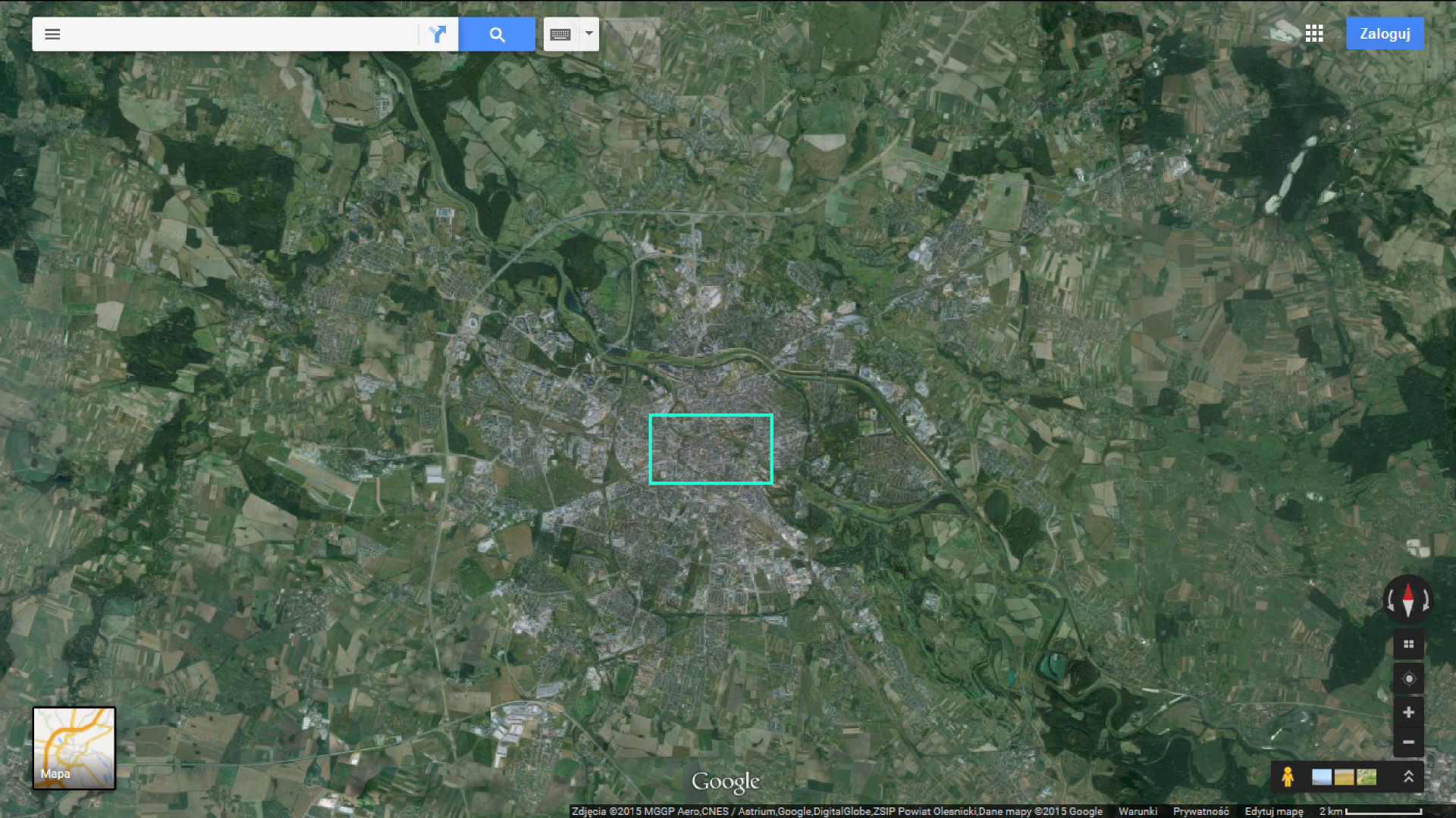 Fotografia przedstawia satelitarny obraz Wrocławia i okolic z aplikacji Google Maps. Dominuje barwa zielona, która oznacza tereny porośnięte roślinnością. Ciemnozielone obszary to parki i lasy. Widoczna w centralnej części zabudowa miasta Wrocławia ma kolor szary lub biały.