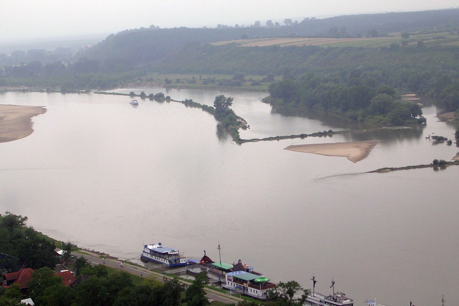 Zdjęcie przedstawia dolny bieg rzeki. Koryto rzeki jest bardzo szerokie. Widoczne piaszczyste wysepki oraz kanały wodne.
