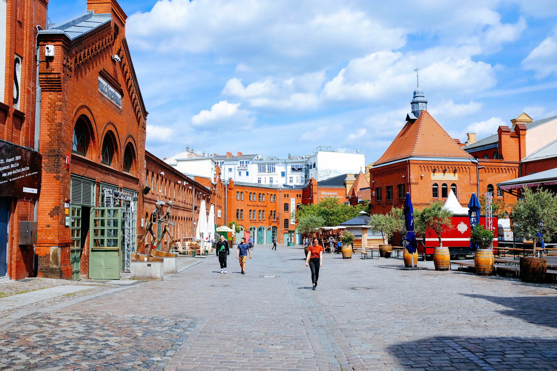Ilustracja przedstawia ludzi ludzi idących ulicą. Na ulicy znajduje się kilka restauracji.