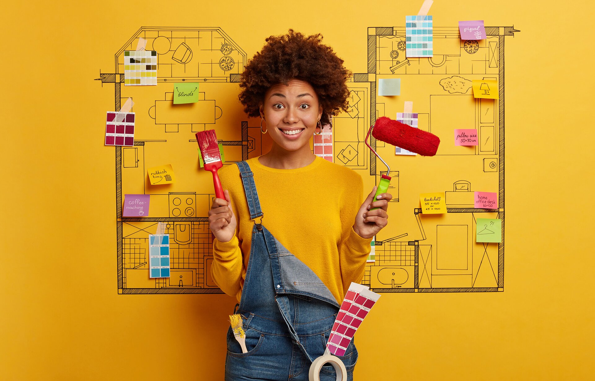 Zdjęcie przedstawia kobietę opierającą się o tablicę, na której przyczepiono różne karteczki z informacjami. Kobieta trzyma w dłoniach pędzel malarski i wałek.